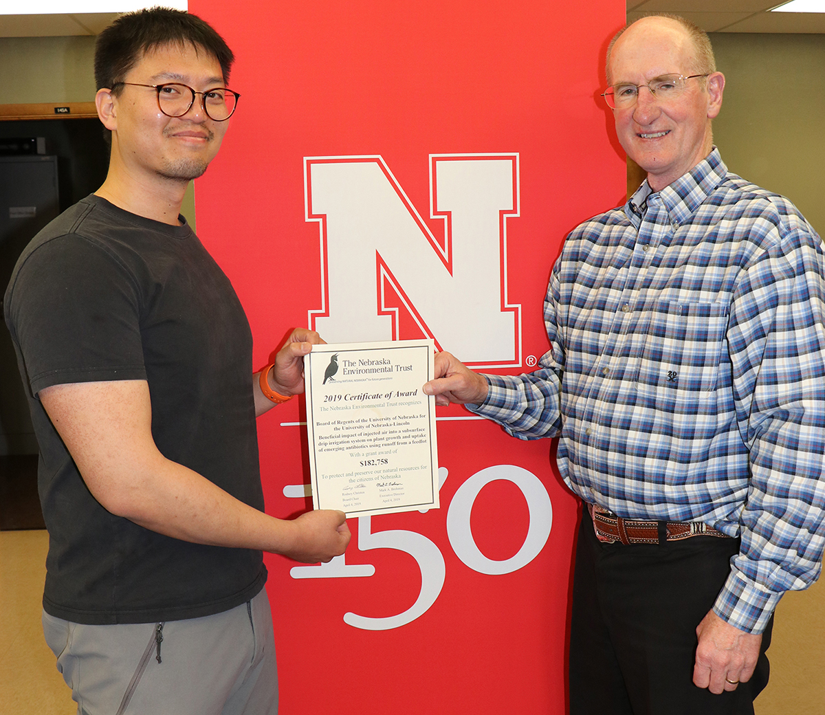 Xin Qiao (left), irrigation and water management specialist and principal investigator, and Jack Whittier, Panhandle Center Director of Research and Extension, accept the award from the Nebraska Environmental Trust fund to establish SDI research with livestock effluent.