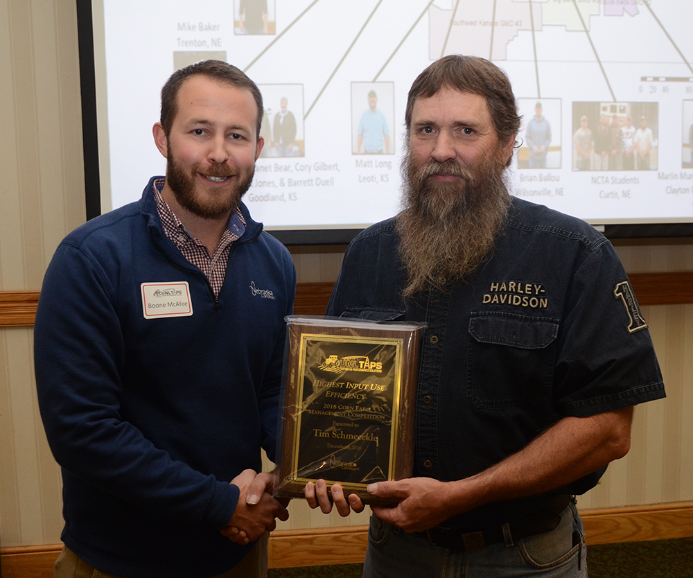 Tim Schmeeckle of Gotherburg receives the award for top input use efficiency from Boone McAfee of the Nebraska Corn Board.