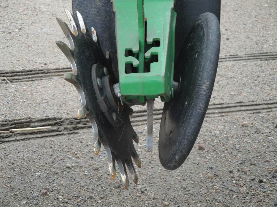 A planter setting with spiked and solid closing wheels