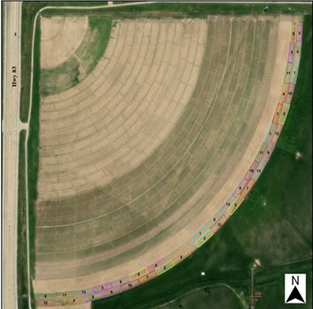 Aerial image of a center-pivot field showing curved crop rows and multiple color-outlined rectangular plots arranged along the pivot arc.
