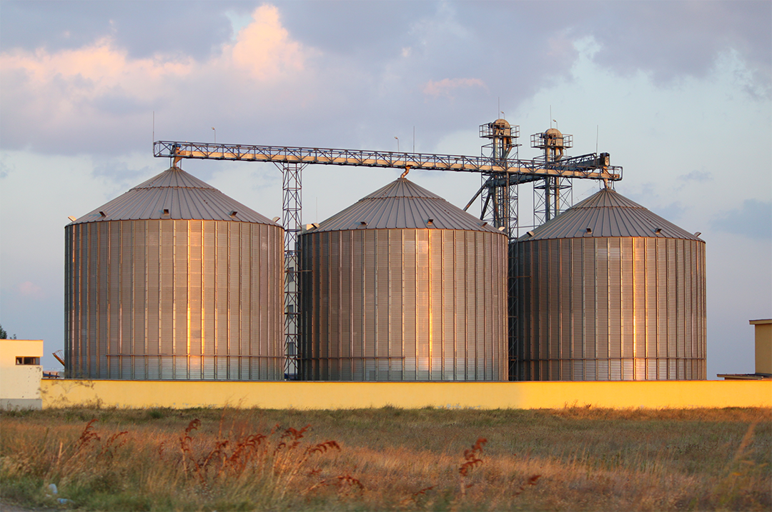 grain bins at sunset