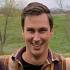 Keith Koch smiles while standing outdoors in headshot