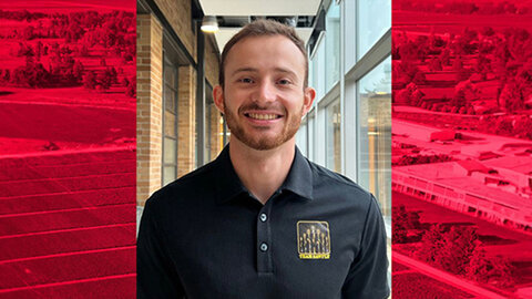 Vinicius Zuppa, UNL Extension Educator, smiling in a hallway while wearing a black Team Beans polo shirt.