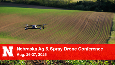 Drone flying over a cultivated field with conference text overlay on a red banner.