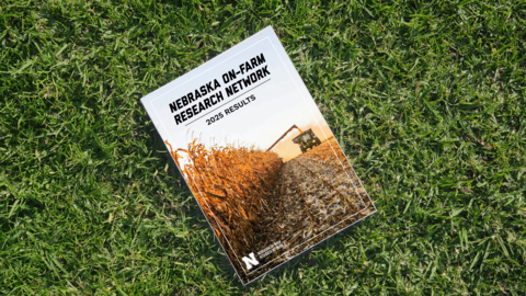 Booklet featuring a cornfield and combine harvester resting on green grass.