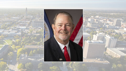 Color portrait of Scott Hutchins, chief scientist and undersecretary for research, education and economics with the U.S. Department of Agriculture, on a color campus background.