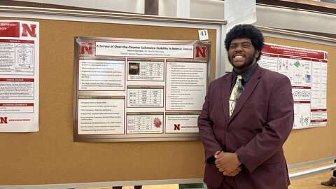Marcus Cureton presents his research during a poster session.