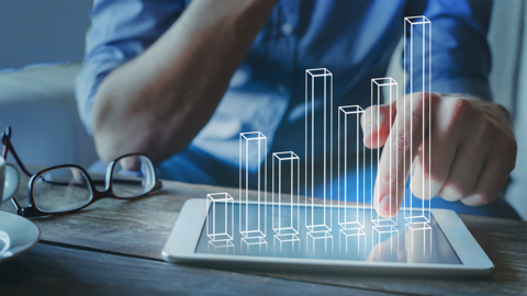 man looking at bar graph on tablet