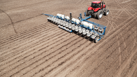 tractor planting field of corn