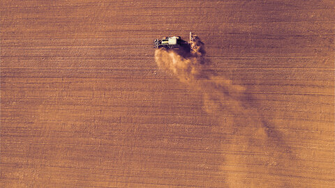 tractor planting dry field during drought
