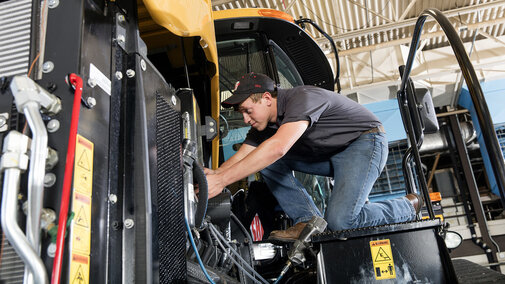 Devon Vancura, a senior agricultural engineering major, checks a connection for a testing monitor in the Nebraska  Tractor Test Laboratory. The facility is the designated tractor testing station for the entire United States. (Photo by Craig  Chandler, University Communication)