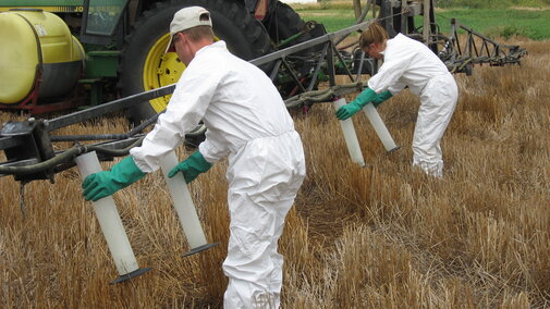 Two workers filling pesticide containers