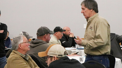 Men speaking near tables
