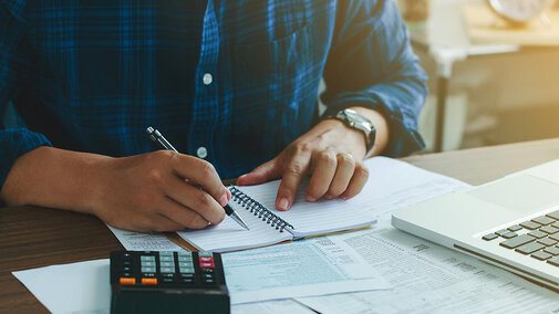 Man filling out tax forms at desk