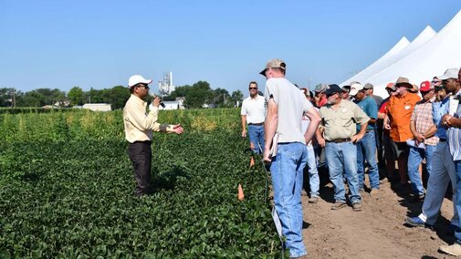 Amit Jhala speaks to attendees while standing in field