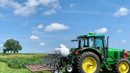 Tractor with flame weeding equipment attached