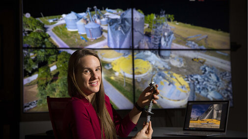 Woman holds rebar near computer