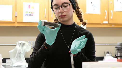 Woman examines specimen tube in laboratory