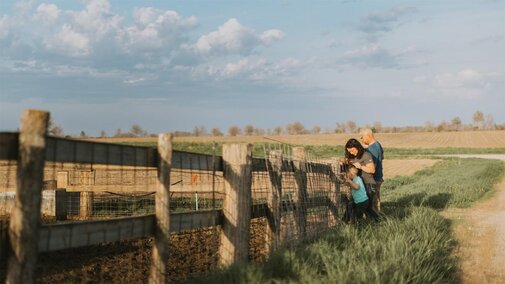 Family standing beside fence