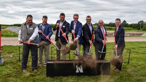 Men hold shovels behind ceremonial dig area