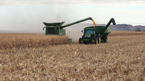 Combine and grain truck harvest corn field