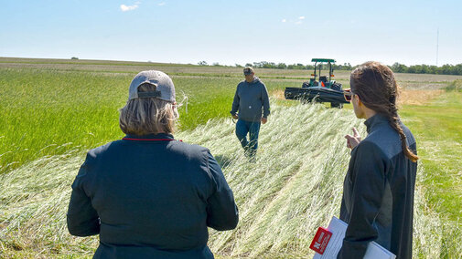 Attendees gather around a roller crimper during a live demonstration at ENREEC.