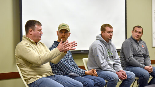 Four Nebraska farmers sit on a discussion panel, with one speaking and gesturing as others listen during a nitrogen management Q&A about Sentinel Ag.