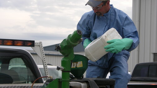 Photo of gloved pesticide applicator