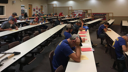 students taking a written test in a college classroom