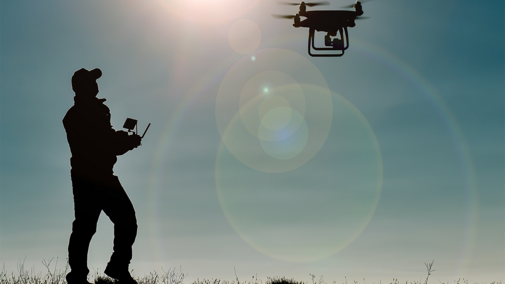 Man operating drone in field