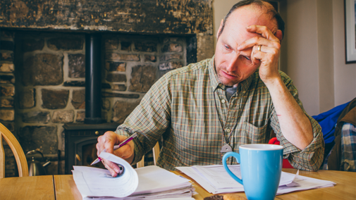Man filling out paperwork at table