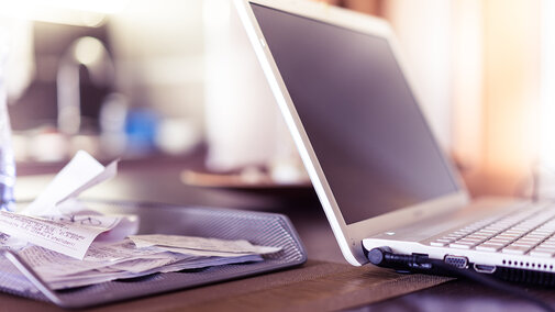 Photo of working with receipts and a home laptop computer