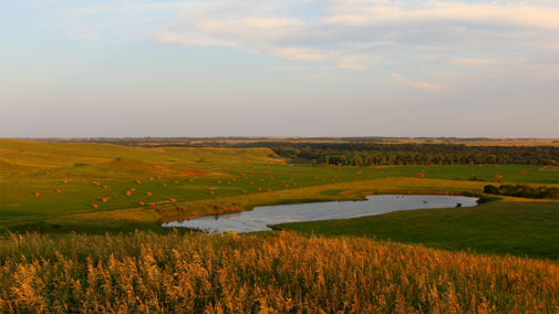 nebraska farm with pond and haybales