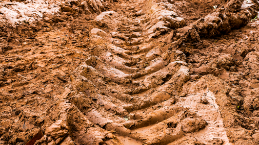 Tire tracks in muddy clay soil