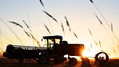 Tractor in field at sunset