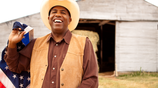 Man holding flag in front of barn