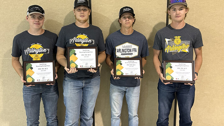 Four Arlington FFA members stand side by side holding first-place plaques from the Nebraska Youth Crop Scouting Competition.