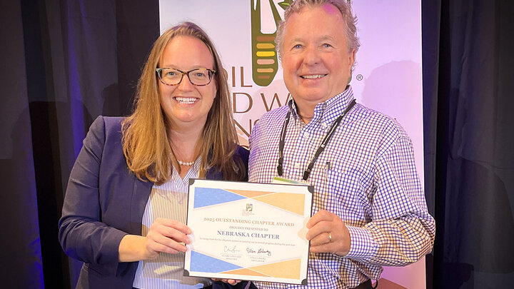 Chapter representative accepts the SWCS Outstanding Chapter plaque from the organization’s leader at the international conference.