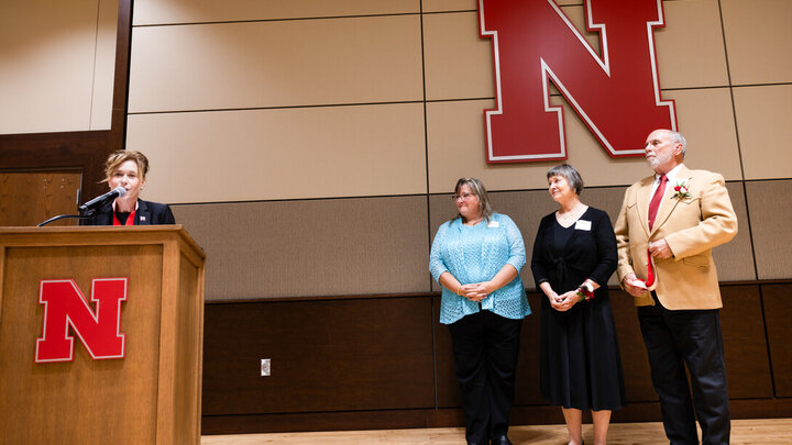 Tiffany Heng-Moss, interim vice chancellor for the Institute of Agriculture and Natural Resources, announces Tamra Jackson-Ziems as the John and Patty Wilson Professor of Plant Pathology, with Patty and John Wilson standing beside her.