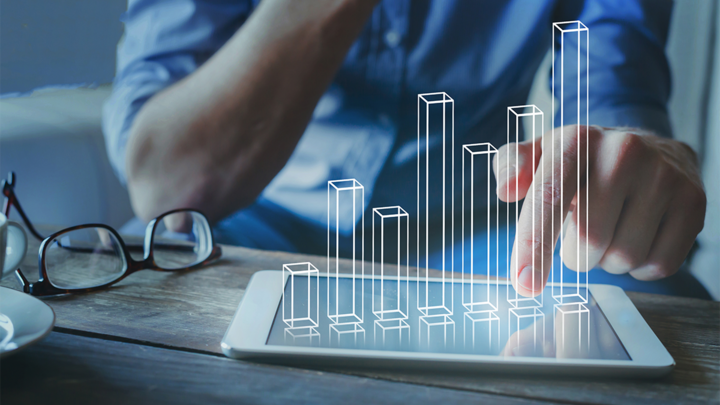 man looking at bar graph on tablet