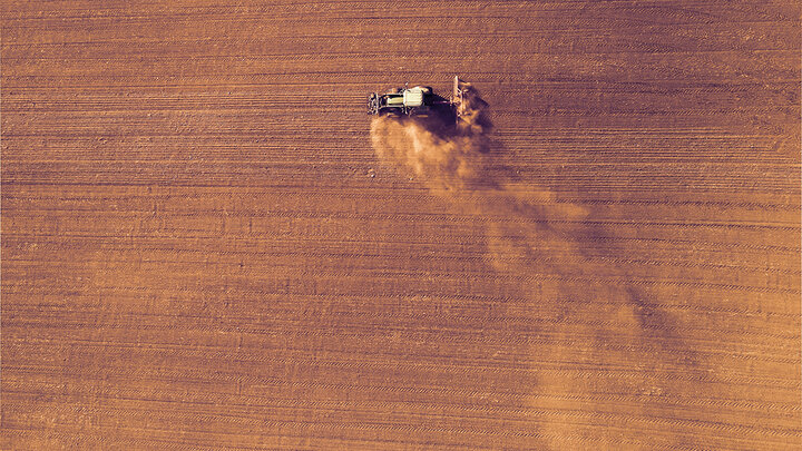 tractor planting dry field during drought