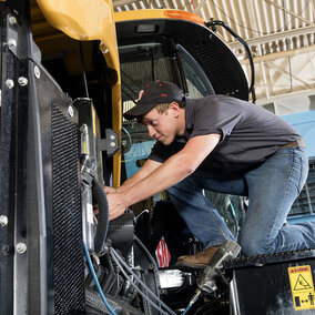 Devon Vancura, a senior agricultural engineering major, checks a connection for a testing monitor in the Nebraska  Tractor Test Laboratory. The facility is the designated tractor testing station for the entire United States. (Photo by Craig  Chandler, University Communication)