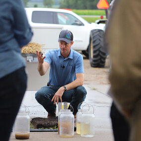 Aaron Hird gestures to soil and water samples