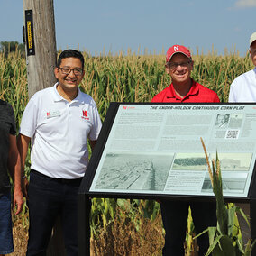 Group photo of Ostdiek, Maharjan, Bischoff and Yoder with sign