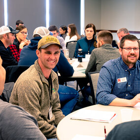 Attendees chat at table during 2023 meeting