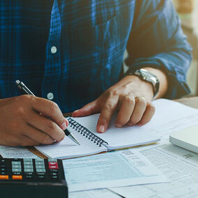 Man filling out tax forms at desk