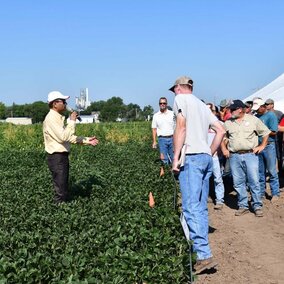 Amit Jhala speaks to attendees while standing in field