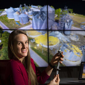 Woman holds rebar near computer