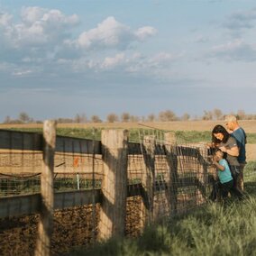 Family standing beside fence