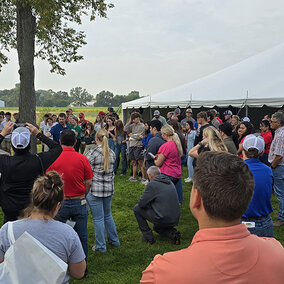 Large group of people surround Nathan Mueller during live rainfall simulation